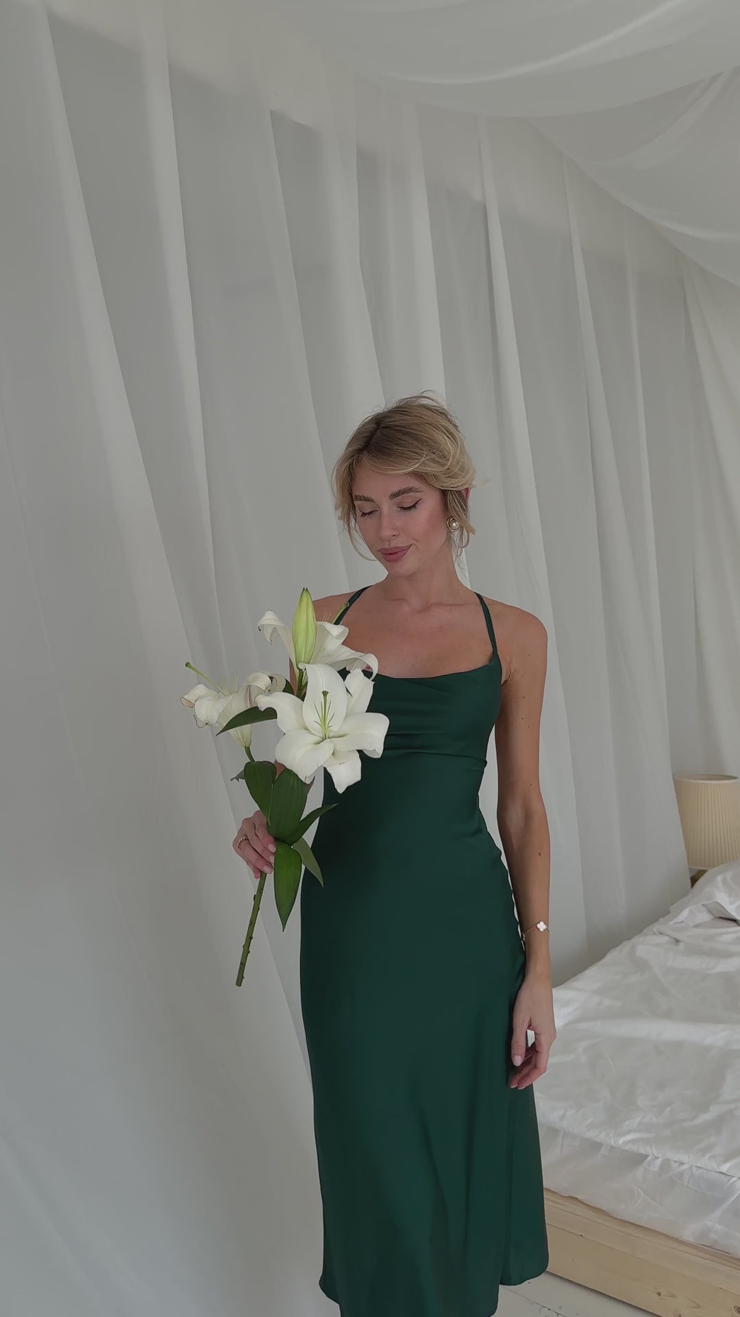 Video overview of emerald green silk satin dress showing adjustable criss-cross ties, perfect for a wedding guest.