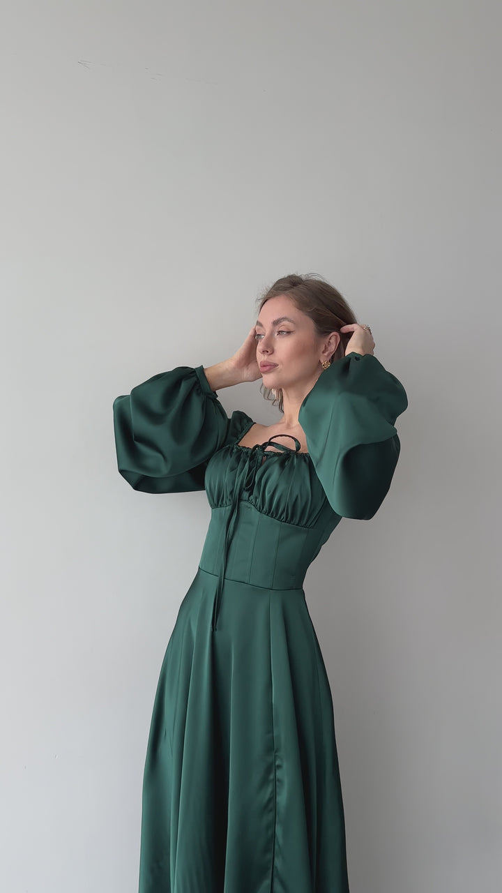 Emerald green silk satin maxi dress with bishop sleeves and high leg slit modelled in motion — EvolveUA