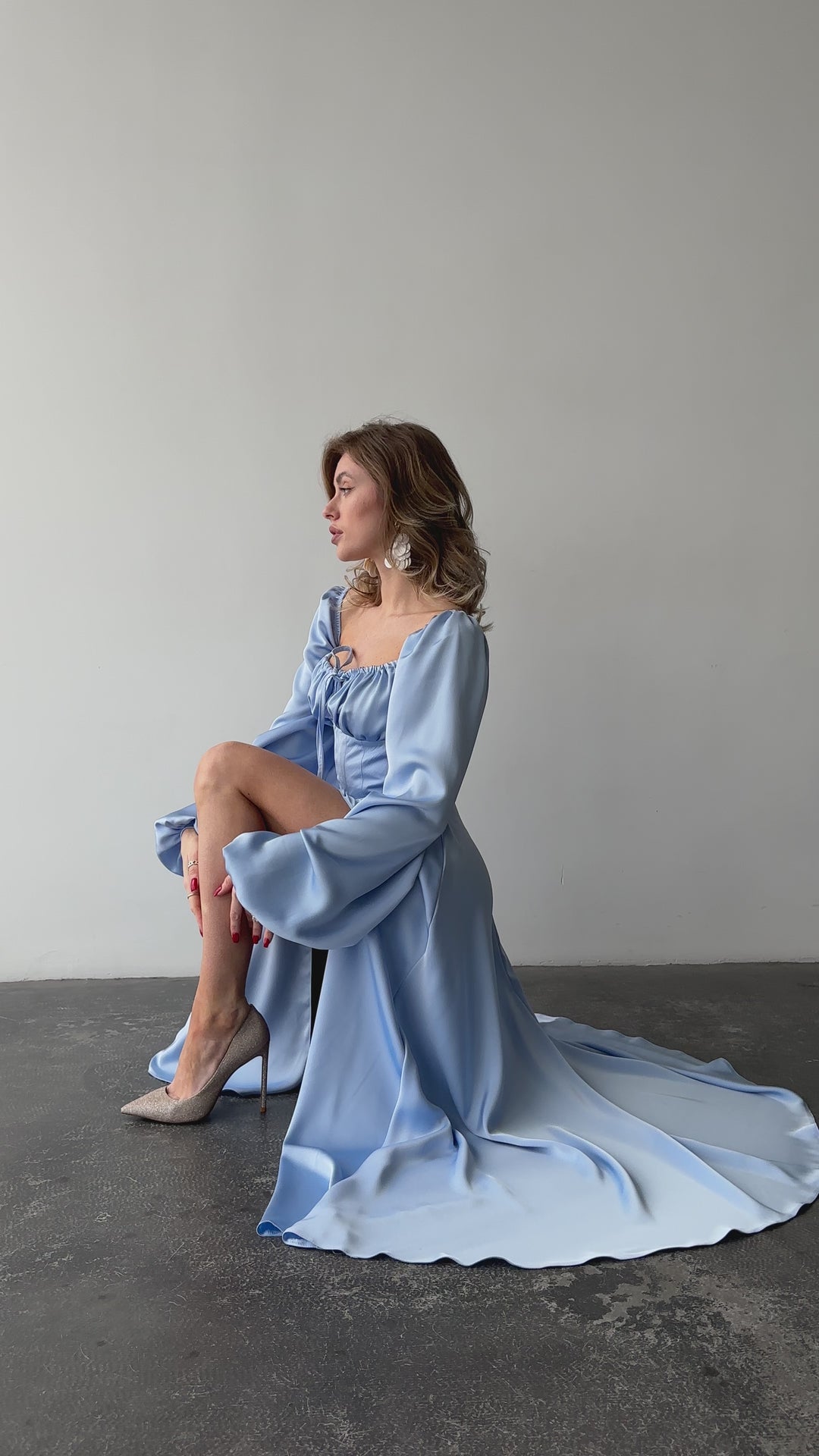 Light blue silk satin maxi dress with bishop sleeves and high leg slit modelled in motion — EvolveUA