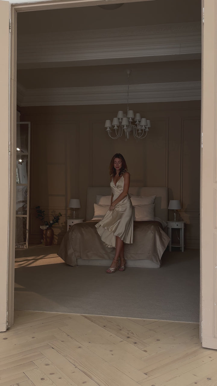 Vanilla silk slip midi dress with deep V-neck and open back modelled in motion — EvolveUA