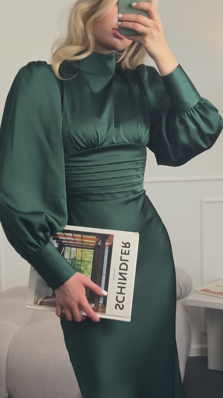 Video of the emerald green midi dress with bow tie back — modelled in motion