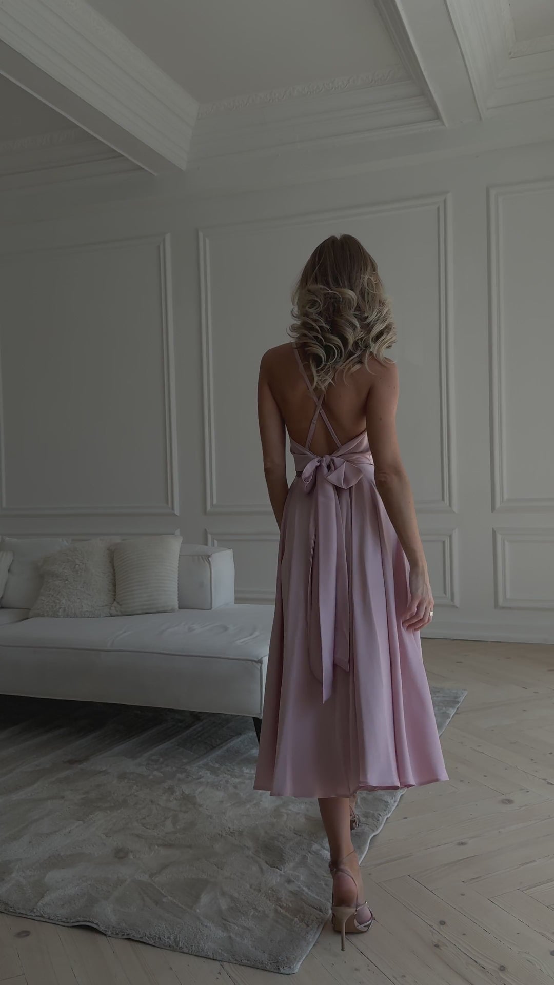 Light pink silk slip midi dress with deep V-neck and open back modelled in motion — EvolveUA