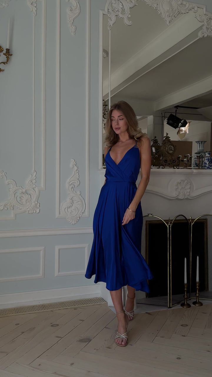Royal blue silk slip midi dress with open back and V-neck modelled in motion — EvolveUA