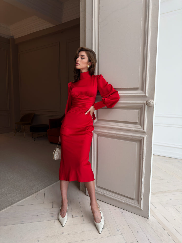 Red satin midi dress, full-length front view with stand collar, puffed long sleeves, pleated high waist and fitted midi skirt with a slight flare at the hem.