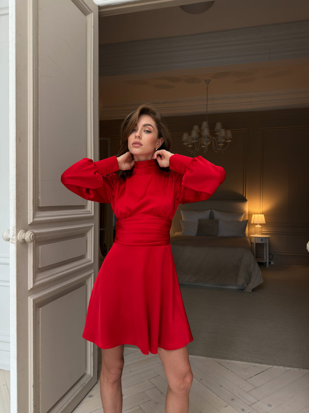 Red silk satin mini dress, front view from collar to hem: pleated high neckline, puff sleeves with cuffs, gathered bust above a pleated waistband and full flared skirt.