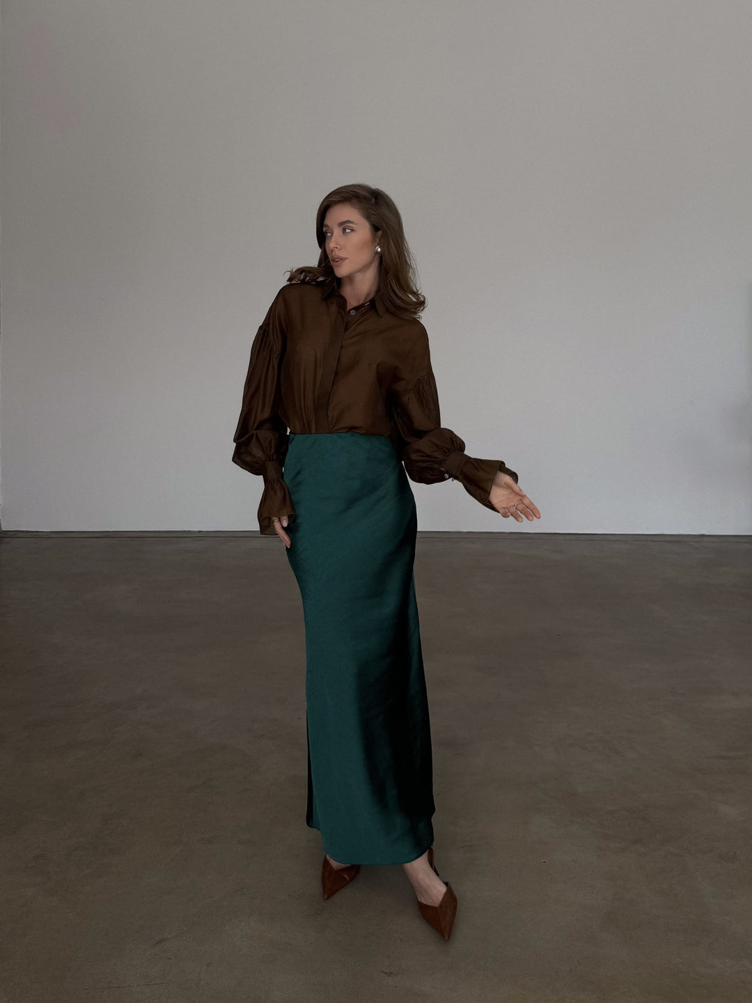 Full-length front profile of a high-waisted forest green slip skirt demonstrating an elevated casual aesthetic.