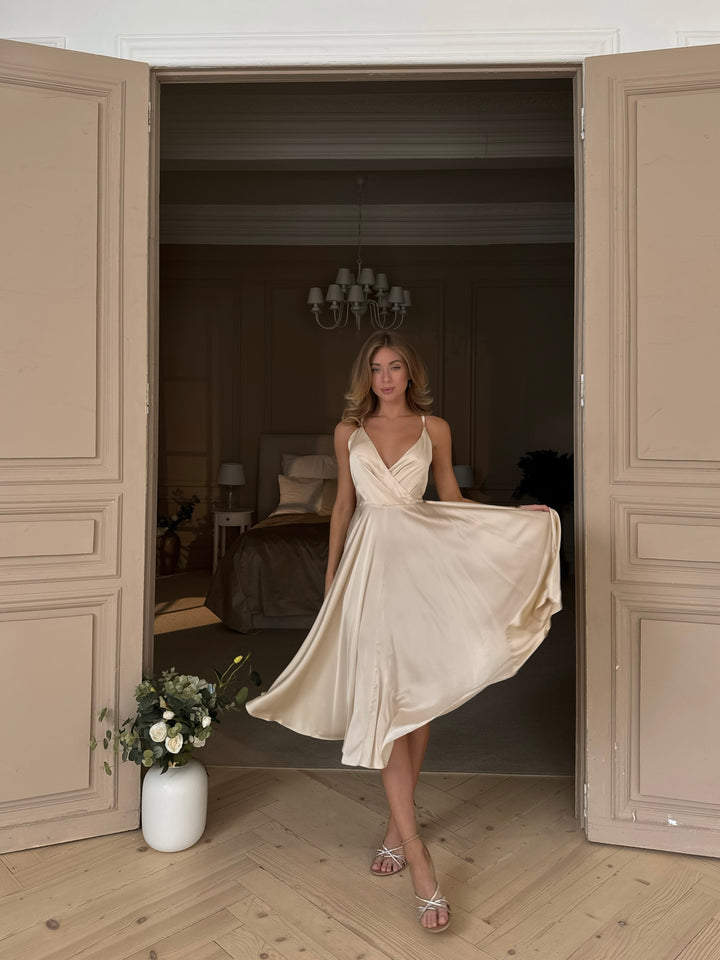 Woman wearing vanilla silk midi dress as bridesmaid or at a civil wedding
