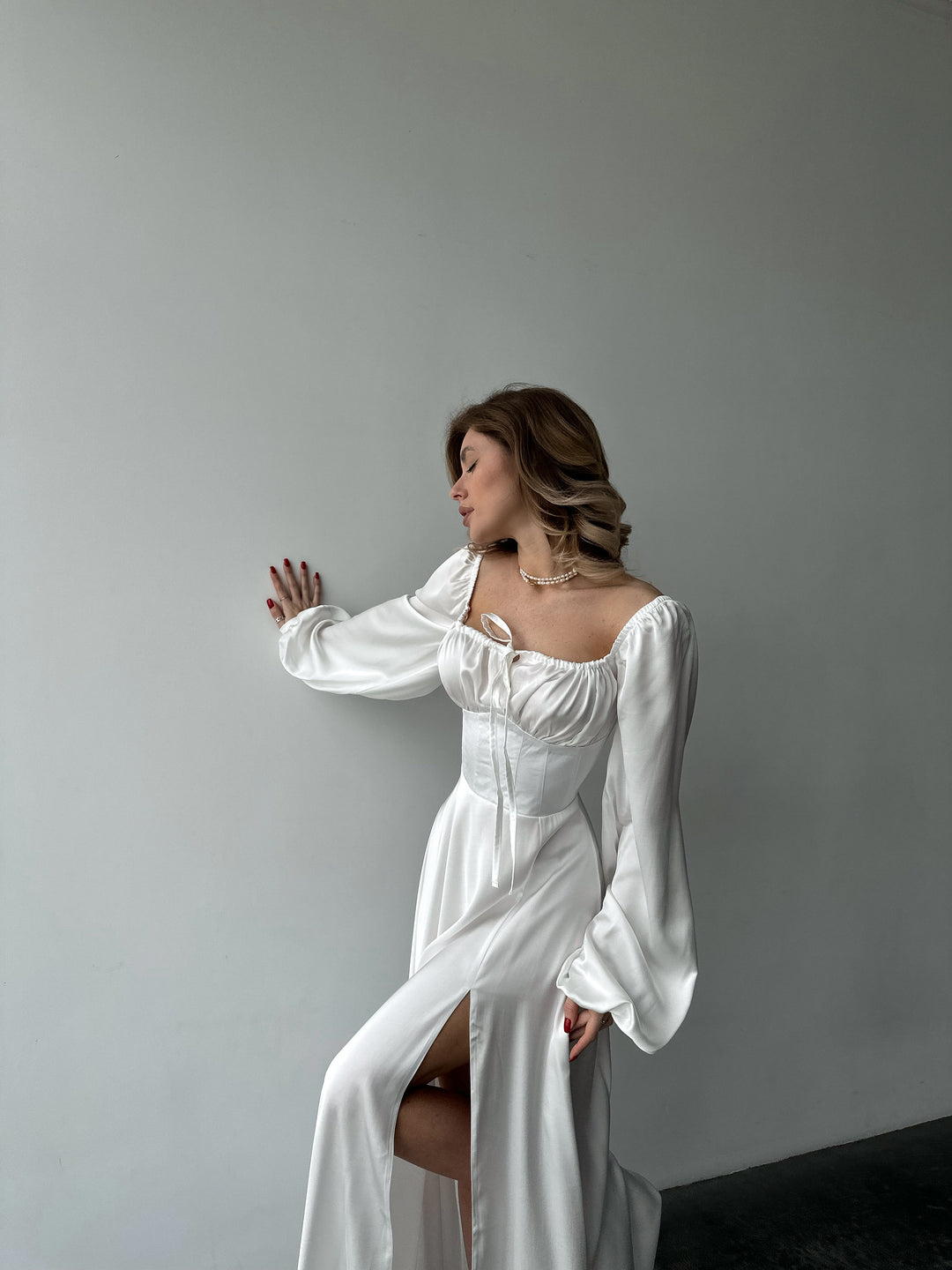Floor-length white satin dress with a flattering sweetheart neckline and versatile draped sleeves. A feminine silhouette perfect for an elegant white party.