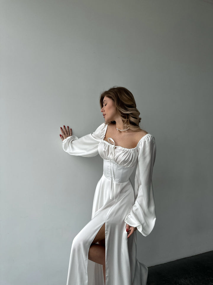 Floor-length white satin dress with a flattering sweetheart neckline and versatile draped sleeves. A feminine silhouette perfect for an elegant white party.