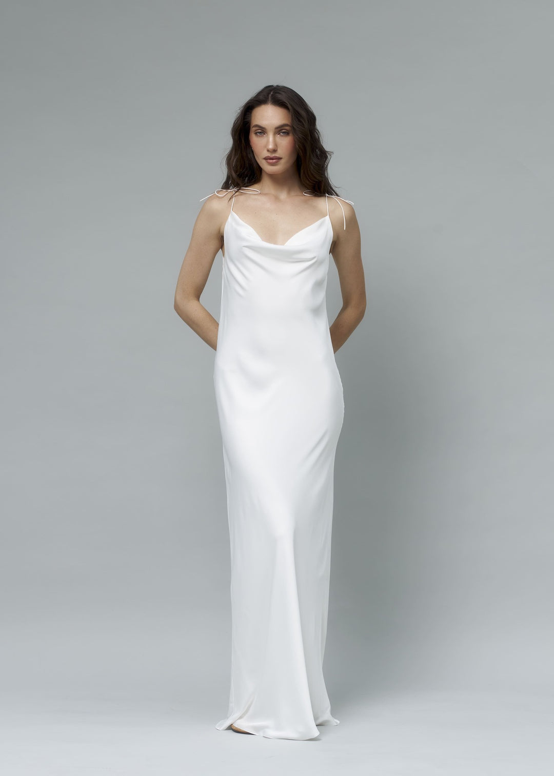 White satin cowl neck maxi slip dress, model posing with hands on hips, elegant minimalist bridal look