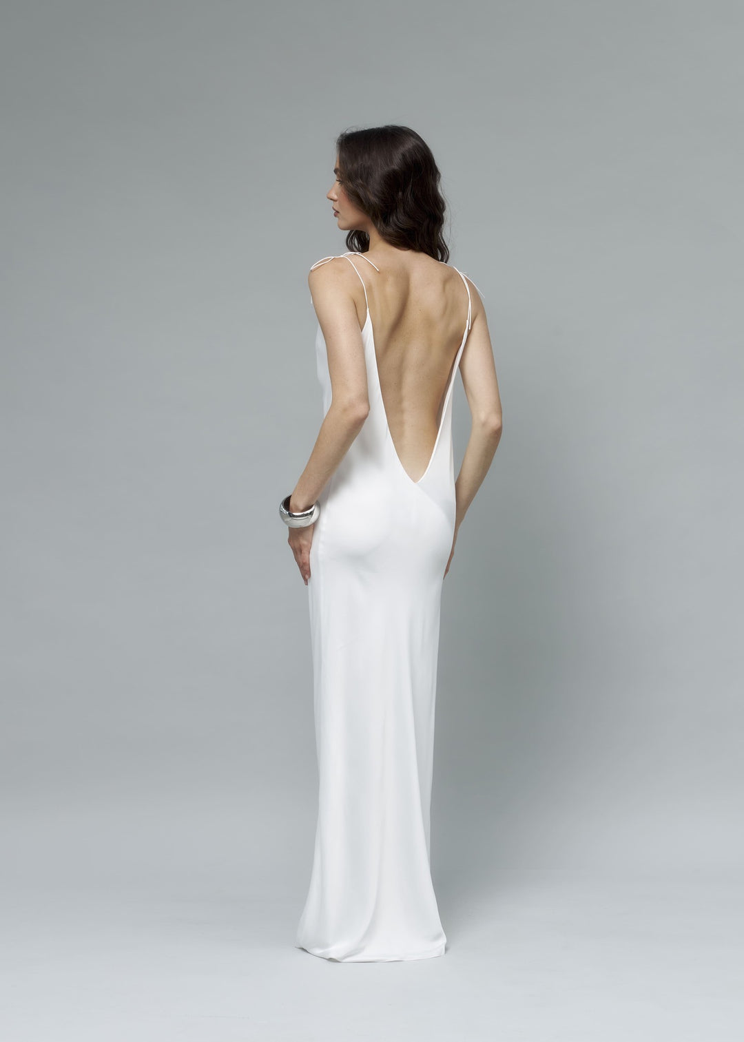 Back view of white satin maxi slip dress featuring a deep V open back with thin straps, full length bridal gown