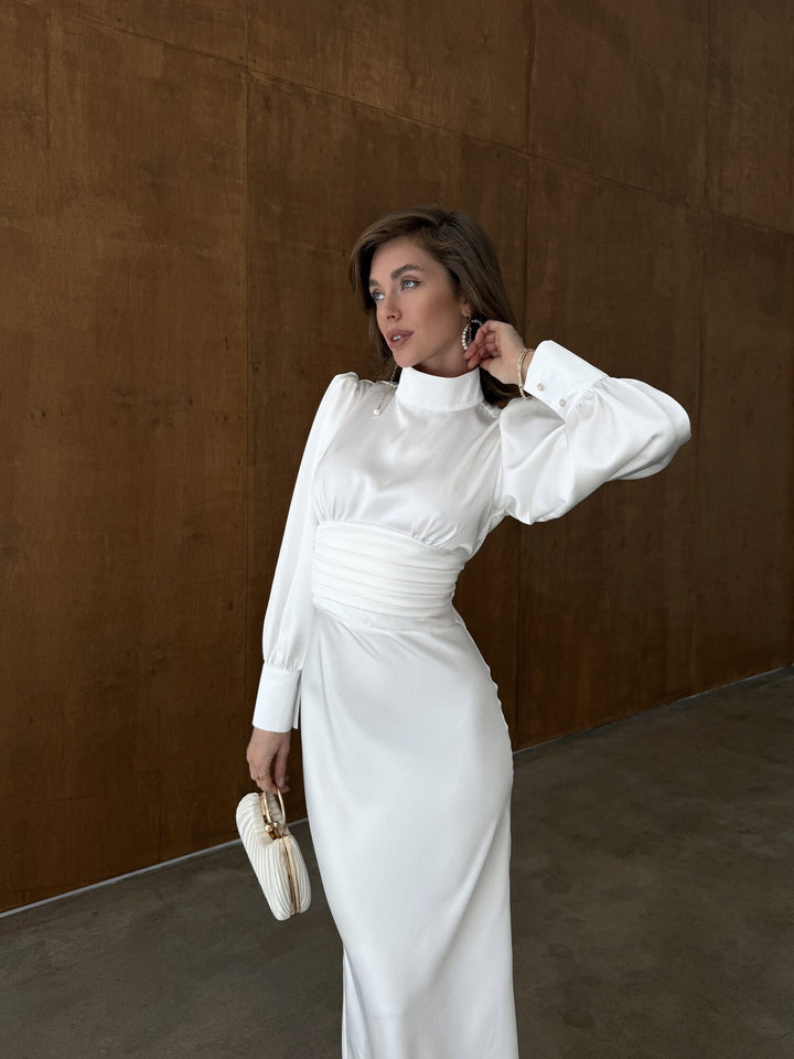 White satin midi dress close up showing high neckline, buttoned cuffs and ruched waistband detail