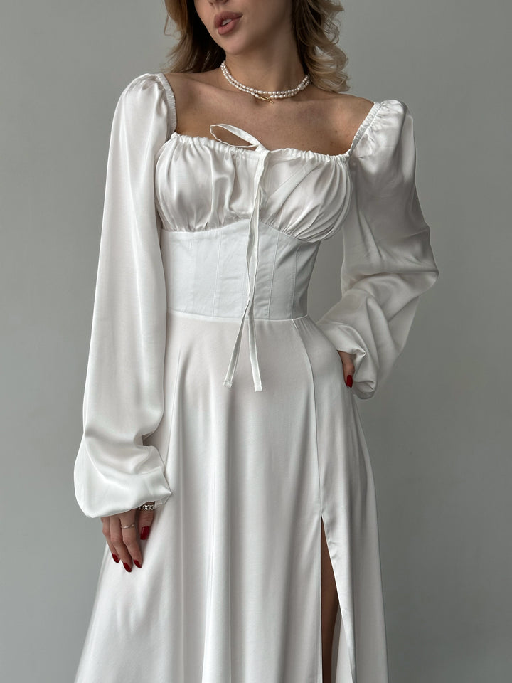 Elegant white silk maxi dress featuring long bishop sleeves and a high side slit. A sophisticated choice for a bridal change dress or formal reception.